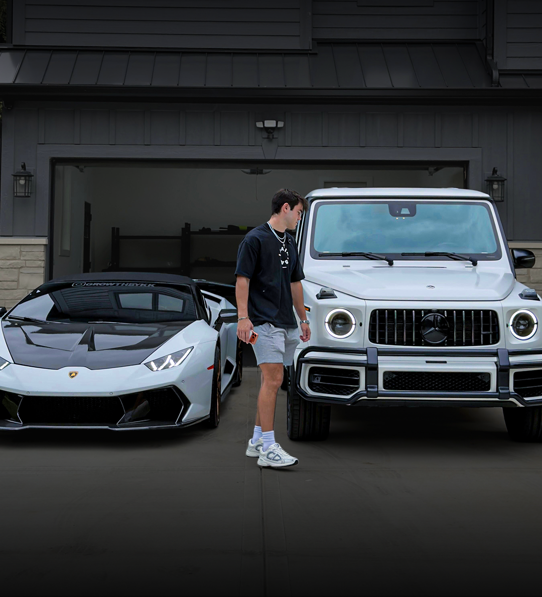 KK, founder of GrowthByKK, standing between a Lamborghini and a G-Wagon